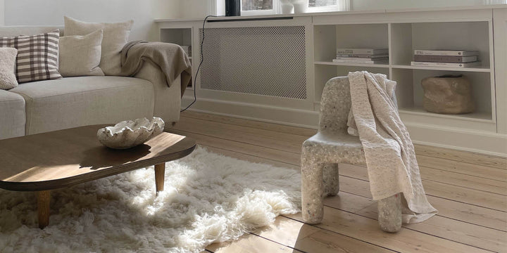 A cosy Scandinavian styled living room with Charlie Chair Off-White and Coral Blanket. 