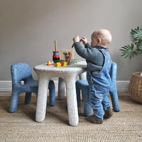 Child playing at Luisa Table, part of blue furniture set Azure